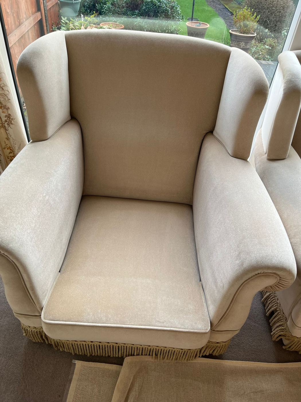 The same wingback armchair after cleaning, the arms and cushion an even cream