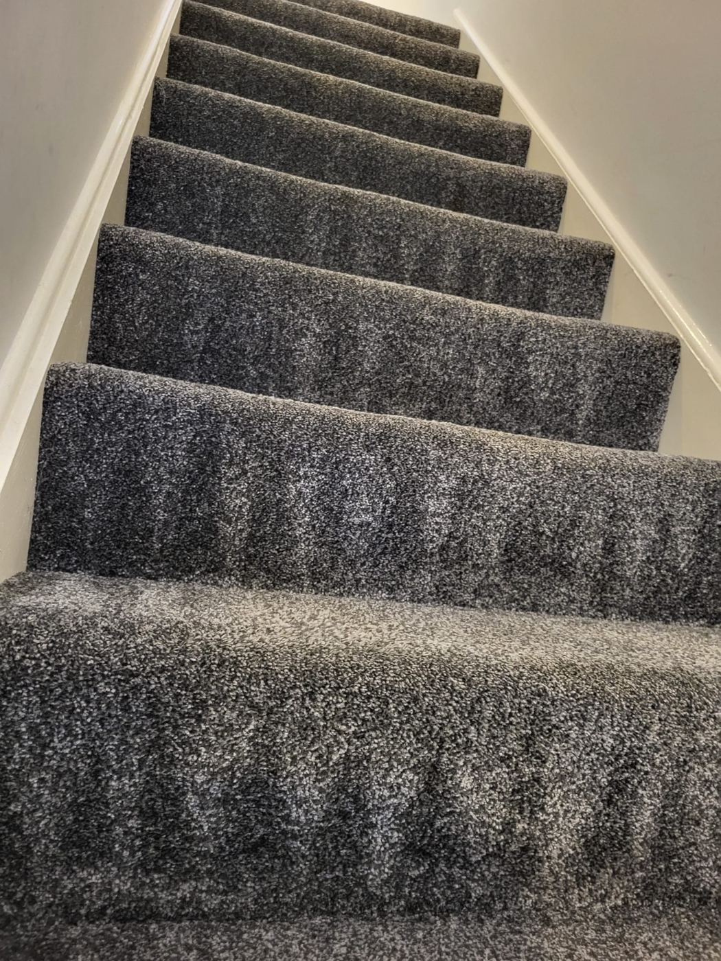 The same grey stairs and landing after cleaning, the pile lifted and even on every tread