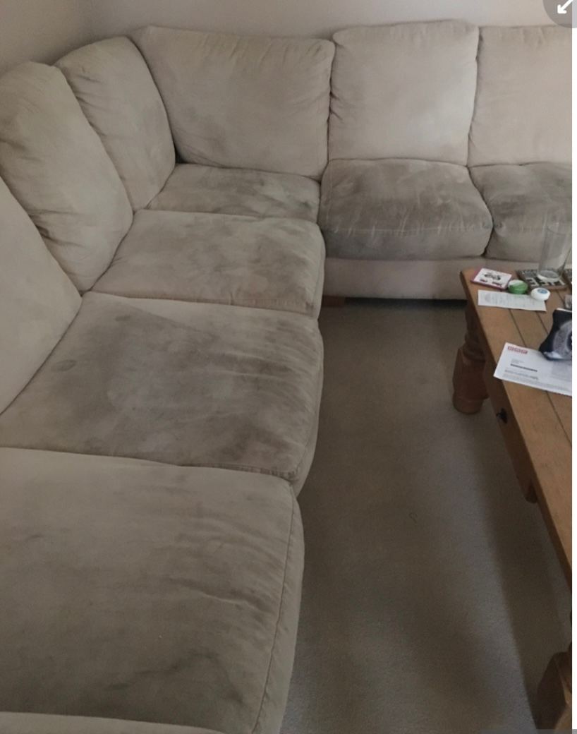A cream corner suite before cleaning, the seat cushions greyed from everyday use