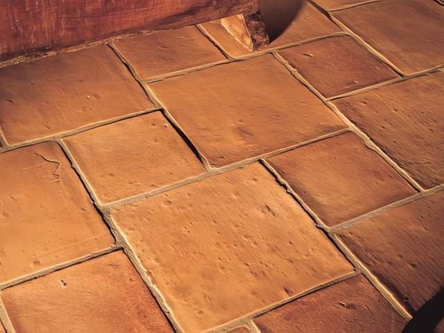 Restored terracotta floor tiles with a warm sealed finish