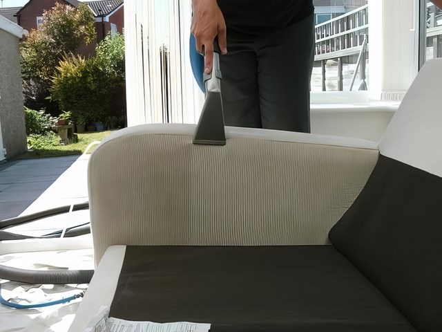 Upholstery cleaning tool on a cream fabric sofa